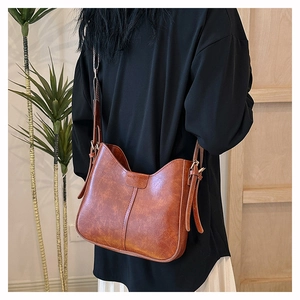 Detailansicht der braunen Vintage PU-Ledertasche mit matter Textur und breitem Riemen