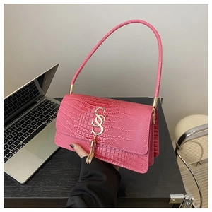 Macro view of rose pink crocodile pattern texture and golden tassel buckle on bag