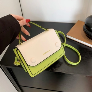 Sac à bandoulière contrasté vert et crème avec détails dorés sur bois sombre