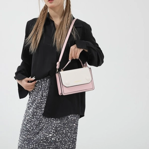 Sac bandoulière bicolore rose et crème avec logo métallique et sangle réglable