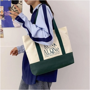 Detail of contrast canvas tote bag featuring RUN ALONE print and dark green shoulder straps