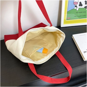 Interior detail of two-tone canvas tote showing zipper closure and inner storage pocket