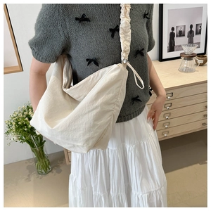 Detailansicht der großen cremeweißen Nylon-Tragetasche mit gerafftem Schultergurt im Cloud-Stil