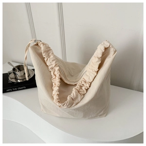 Detail of off-white nylon tote bag with unique ruched scrunchie strap and zip closure
