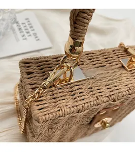 Close-up of woven straw handbag with shiny gold metal lock and elegant woven handle
