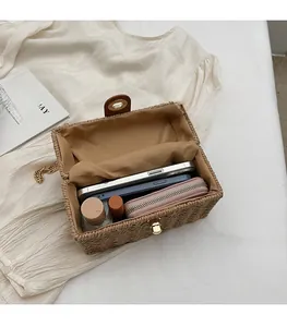 Detailed interior of woven straw box bag showing space for phone and wallet