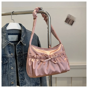 Detailed view of light pink pleated nylon shoulder bag with elegant bow design