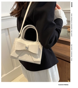 Détail du sac beige en cuir avec grand nœud et cristal en forme de cœur étincelant