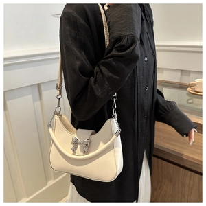 Détail du sac à bandoulière en cuir blanc crème avec boucle nœud argentée et sangle