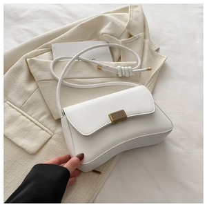 Detail of white PU leather crossbody bag with elegant gold vertical textured metal lock