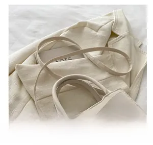 Détail du sac à main blanc crème avec nœud élégant et bandoulière réglable