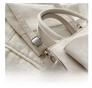 Détail de la bandoulière réglable en cuir et boucle métallique argentée du sac à main