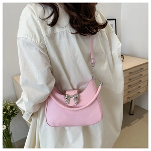 Gros plan du sac hobo rose avec un détail de nœud en métal argenté et texture cuir lisse