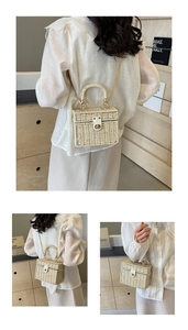 Detailed view of rectangle woven straw bag with golden chain strap and metal turn-lock
