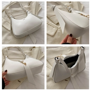 Detail view showing white hobo bag with gold hardware, zipper closure and dark lining