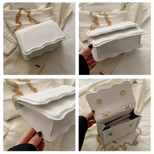 Détails montrant le grain de litchi blanc et le design ondulé du rabat du sac
