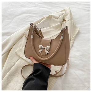 Détail du sac hobo avec boucle noeud argenté et bandoulière chaîne sur cuir kaki
