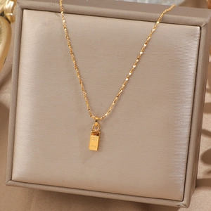 Collier luxueux avec pendentif lingot d'or et gravure sur un écrin en soie fine