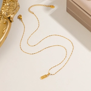 Collier pendentif lingot d'or avec gravure 999.9 sur un cadre photo vintage