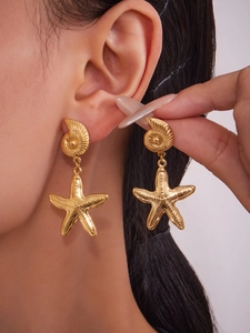 Macro detail of 18k gold plated starfish and shell earrings on model showing fine texture
