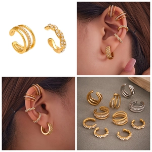 Detalle de pendientes ear cuff de tres capas con circonitas en oro y plata