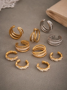 Detalle de pendientes ear cuff de tres capas en oro y plata con circonitas blancas