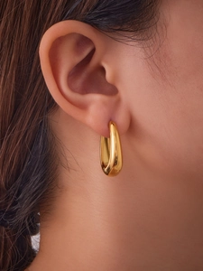 Gros plan de boucles d'oreilles en forme de U plaquées or 18 carats sur un modèle
