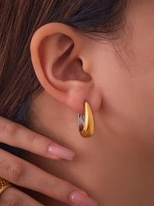 Gros plan de boucles d'oreilles créoles bicolores en forme de U en or et argent