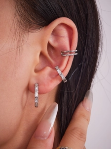 Gros plan de boucles d'oreilles géométriques argentées et ear cuffs avec oxydes