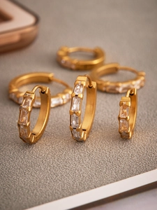 Gros plan de boucles d'oreilles huggie plaquées or 18 carats serties de zircons