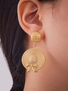Detail of gold woven hat drop earrings with bow detail on female model for chic resort style