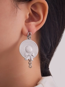 Detail of silver sun hat earring with bowknot and chain on a female model's ear