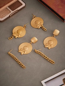 Detailed close-up of 18k gold plated straw hat earrings with elegant chain tassels