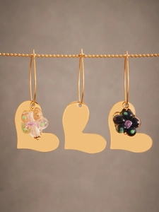 Vue détaillée de boucles d'oreilles cœur en or avec pendentifs fleurs en résine