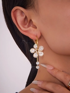 Detailed view of 18K gold plated flower earrings with 5A zircon crystals on a model