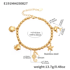 Detail of ocean-themed gold beaded bracelet with shell star fish and dolphin charms