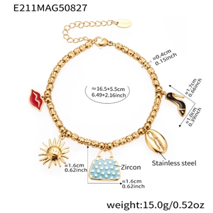 Detail of stainless steel gold bracelet with charms including red lips and zircon accents