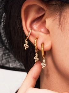 Close-up of 18k gold plated snake drop earrings with sparkling cubic zirconia on model