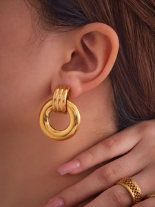 Detailed view of irregular chunky gold hollow hoop earrings with a polished 18k finish