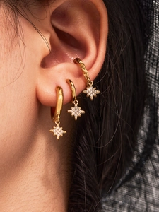 Detailed close-up of 18k gold plated star pendant earrings set with zircon stones