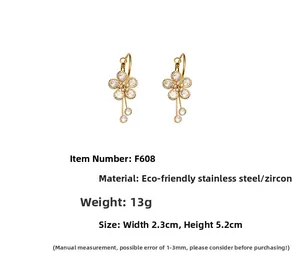 Detail view of gold flower earrings with sparkling zircons and stainless steel specs
