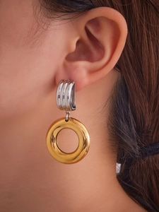 Detail of mixed-metal irregular hollow hoop earrings shown on a model side view