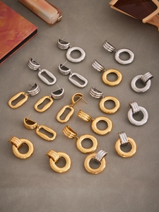 Flat lay of irregular hollow geometric earrings in polished 18k gold and silver finish