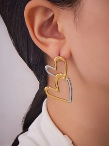 Detail shot of large interlocking double heart earrings in two-tone gold and silver finish