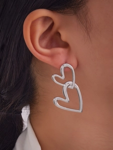 Macro view of interlocking double heart drop earrings with polished silver finish