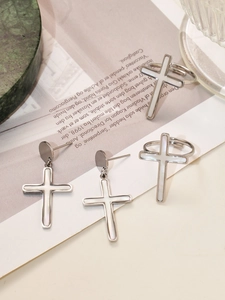Dettaglio del set gioielli a croce in argento con intarsio in conchiglia su sfondo chic