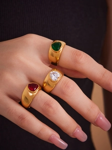 Detailed view of three chunky 18k gold plated heart rings with colorful zircon stones
