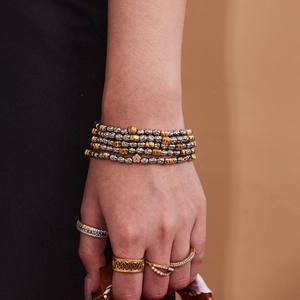 Stacked stainless steel bead bracelets with heart charms and assorted gemstone rings