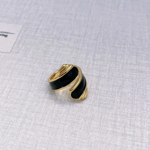 Detailed macro view of vintage gold ring with black enamel glaze and textured open band
