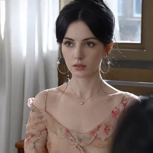 Elegant gold hoop earrings with pearls worn by model in a stylish floral outfit